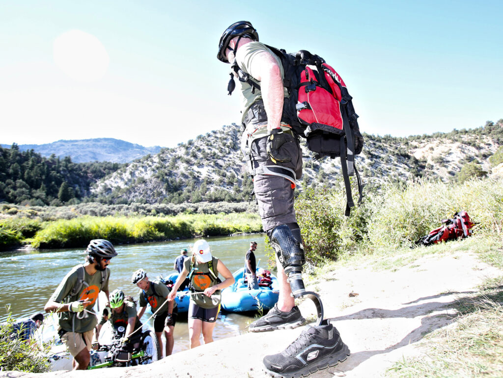 An adaptive athlete watches as a raft unloads