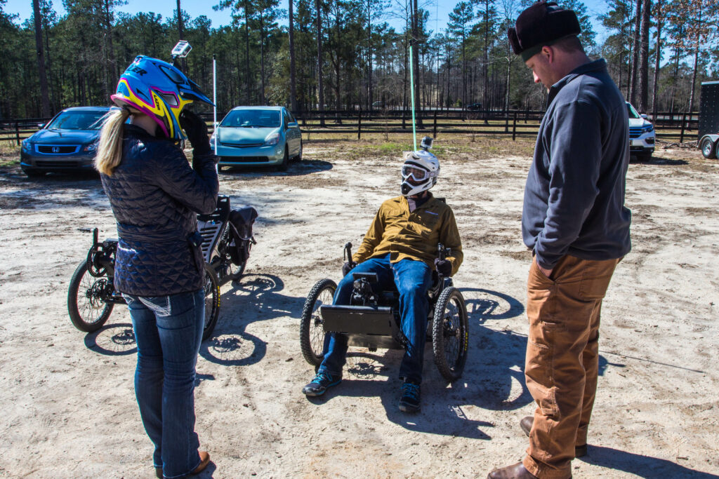 Ellerbe Kinard talks with a veteran on an Outrider USA electric adventure vehicle.